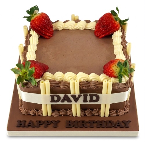 Square chocolate birthday cake with fresh strawberries, white chocolate sticks, and a custom name ribbon.