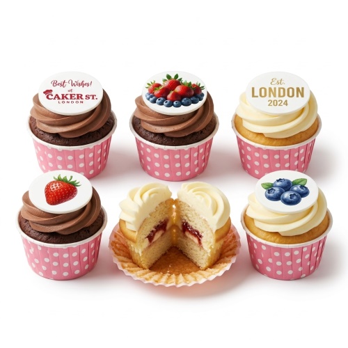 Assortment of chocolate and vanilla cupcakes with fruit and custom message toppers in pink polka dot wrappers.