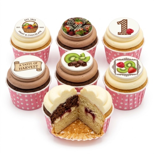 Assortment of cupcakes with white and chocolate frosting, topped with fruit and chocolate themed edible discs, including a custom age '1' topper.