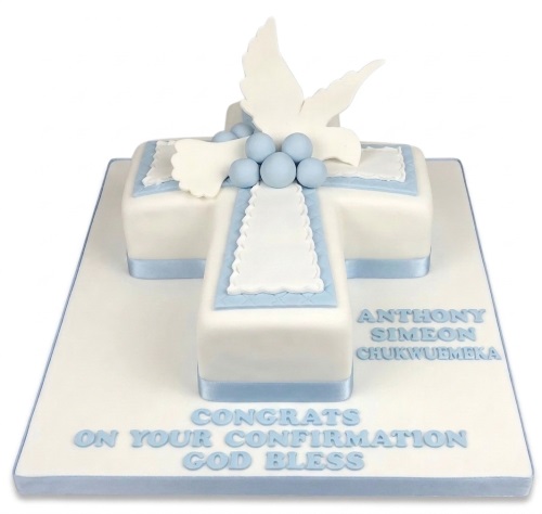 White cross-shaped Confirmation cake with a dove topper and blue accents