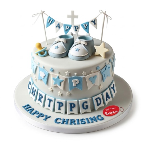 White Christening cake with blue baby booties, cross, dummy, and "Happy Christening" message.