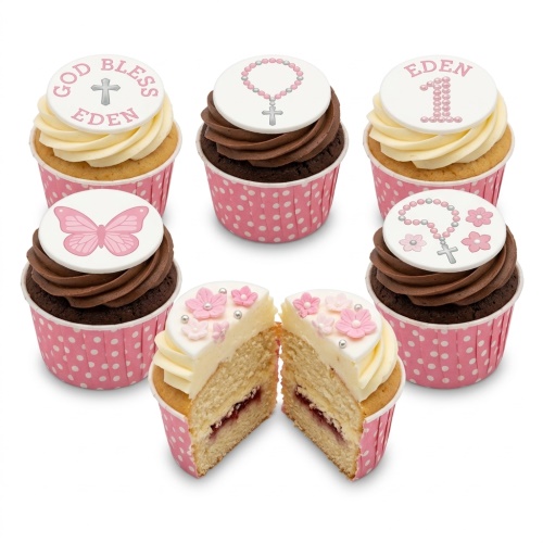 Pink and white cupcakes with cross, rosary, butterfly, and floral toppers for a baby girl's celebration.