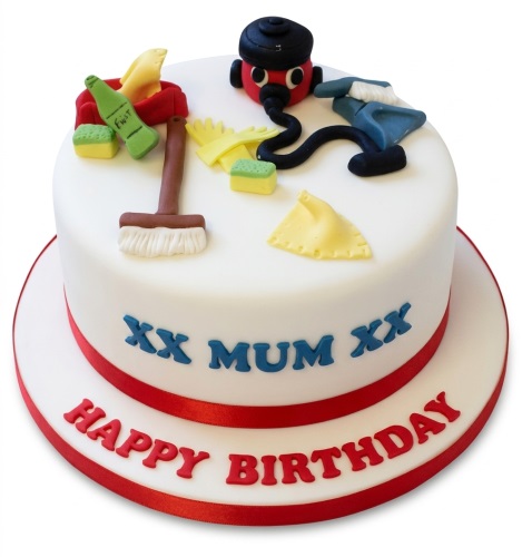 White round birthday cake with red ribbon, decorated with edible cleaning items like a red vacuum, broom, gloves, and sponge.