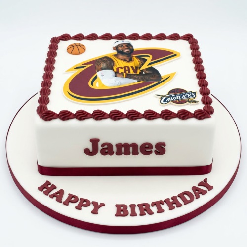 Square white birthday cake with a basketball player image and a small 3D basketball, decorated with maroon icing.