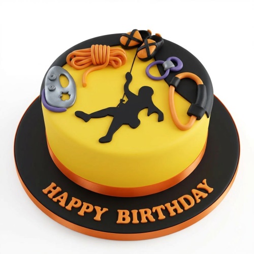 Round yellow and black birthday cake with a climbing theme, featuring a climber silhouette, rope, shoes, and carabiners.