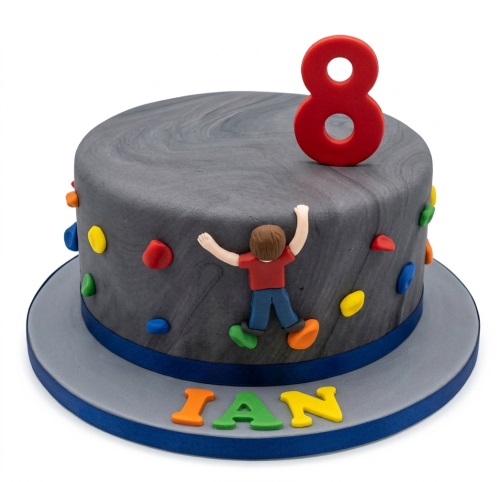 Round grey rock climbing birthday cake with a boy figure, colourful holds, and a red custom age topper.