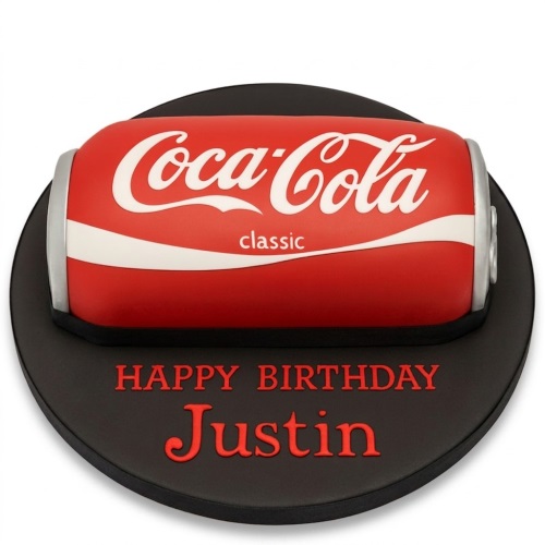 Red Coca-Cola Classic can shaped birthday cake on a black board with a custom message.