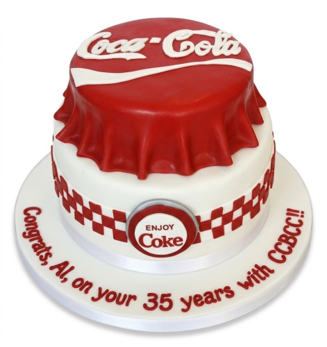 Two-tier red and white Coca-Cola theme celebration cake with bottle cap design and 'Enjoy Coke' emblem.