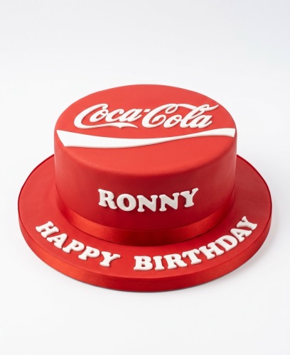 Round red birthday cake with white Coca-Cola logo and 'Happy Birthday' message.