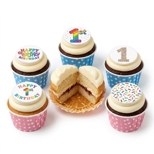 Assortment of 1st birthday cupcakes with rainbow and sprinkle '1st' toppers, in blue and pink wrappers.