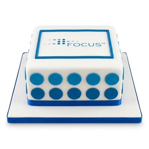 White square corporate logo cake with blue polka dots and a 'FOCUS 2.0' edible logo.