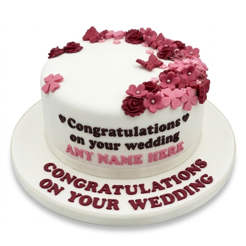 White round cake decorated with pink and maroon fondant flowers and butterflies, with a custom message.