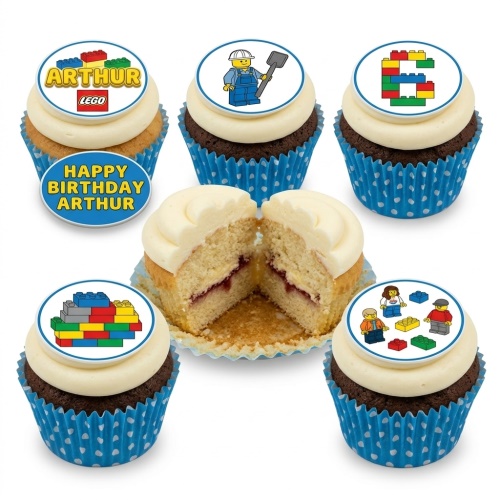 Cupcakes with white frosting and blue polka dot liners, topped with various LEGO brick and minifigure designs.