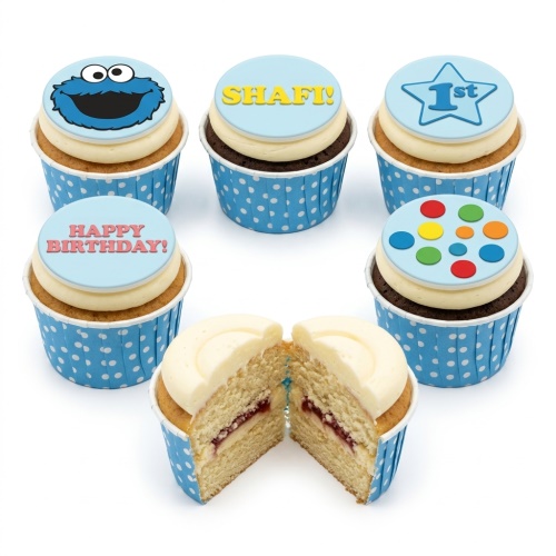 Assortment of birthday cupcakes with Cookie Monster, personalised name, and '1st' toppers in blue polka dot wrappers.