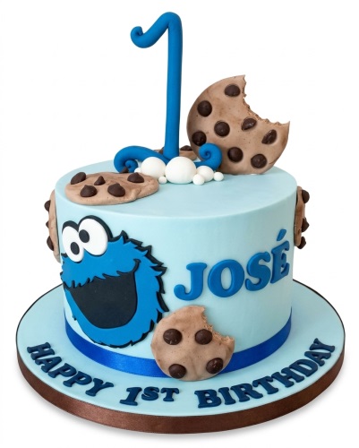 Light blue Cookie Monster 1st birthday cake with number one topper, chocolate chip cookies, and personalised name.