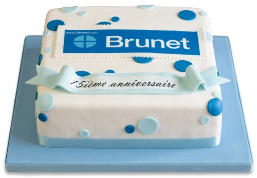 Square white cake with blue polka dots, a blue 'Brunet' logo plaque, and a banner reading '75th Anniversary'.