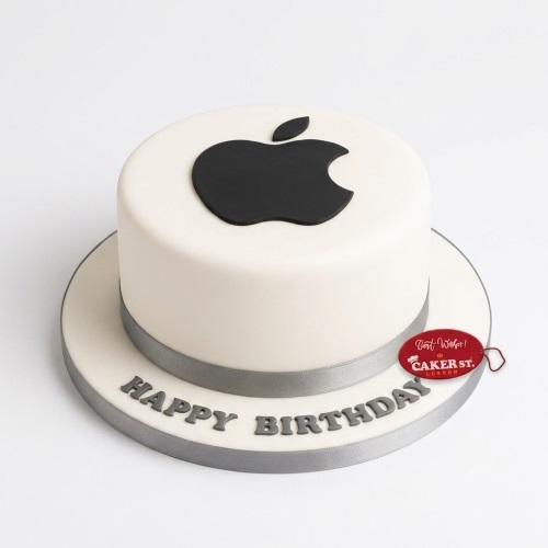 Round white fondant cake with a black Apple logo on top and 'Happy Birthday' text on the board.