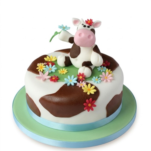 Round white and brown cow print cake with a 3D fondant cow figurine and colourful fondant flowers on top.