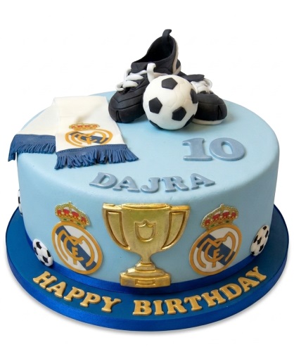 Light blue Real Madrid football birthday cake with edible boots, ball, trophy, scarf, and custom age.