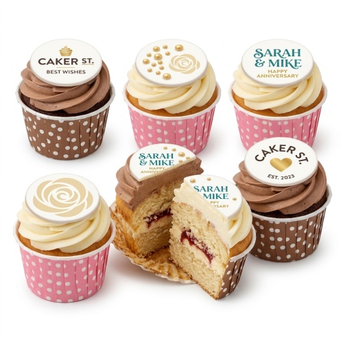 Assortment of anniversary cupcakes with customisable toppers, floral designs, and gold pearls.