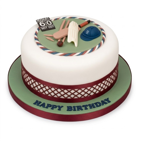 White and green round cricket-themed birthday cake with edible bat, pads, ball, helmet, and custom age scoreboard.