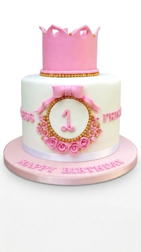 White and pink princess crown birthday cake with gold details and floral decorations.