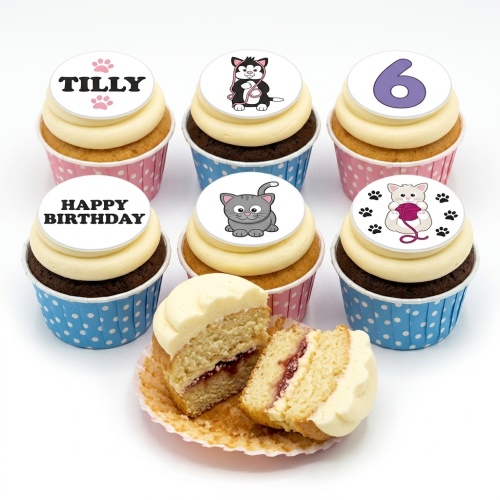A selection of cat theme birthday cupcakes with white frosting, some with light sponge and some with dark sponge, in pink and blue polka dot cases. Toppers include various cartoon cats, a number, a name, and 'Happy Birthday'.