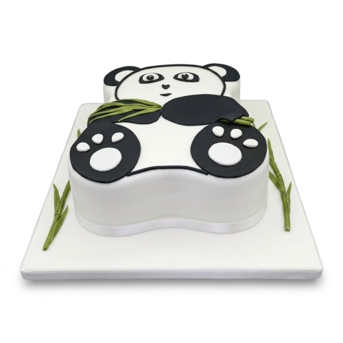 White and black panda shaped birthday cake with green bamboo decorations.