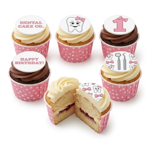 A selection of dental theme cupcakes with white and chocolate frosting in pink polka dot cases. Toppers include a cartoon tooth with a pink bow, dental tools, 'DENTAL CAKE CO.', 'HAPPY BIRTHDAY!', and a pink number '1' with a bow.