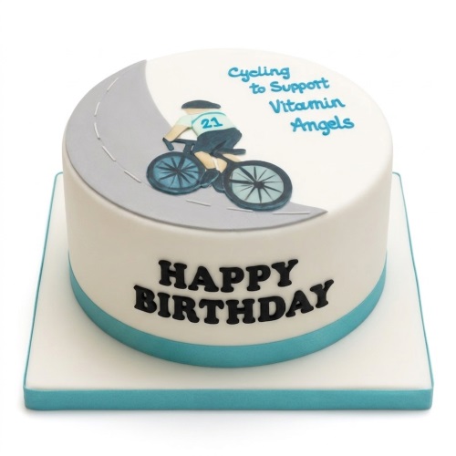 White round birthday cake with a fondant cyclist on a grey road path and "Happy Birthday" message.