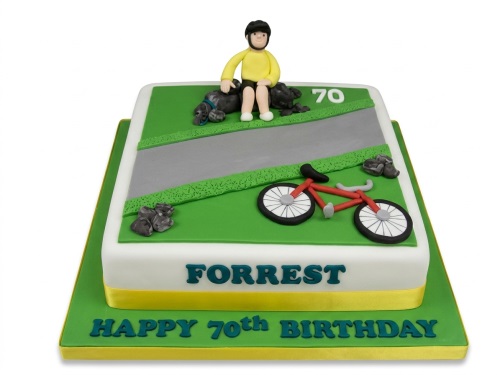 Square birthday cake with a cyclist figure, dog, red bicycle, road, and custom age topper.