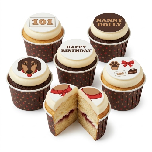 A selection of cupcakes with cream frosting and edible toppers featuring a dachshund dog face, a paw print, a red bow, a slice of cake, and text 'Happy Birthday'.