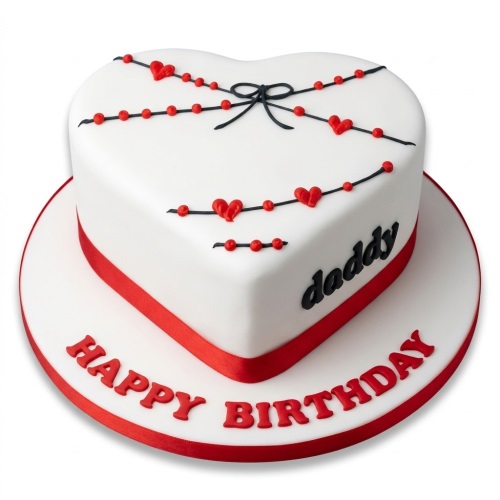 White heart-shaped birthday cake with red hearts, black lines, and red ribbon.
