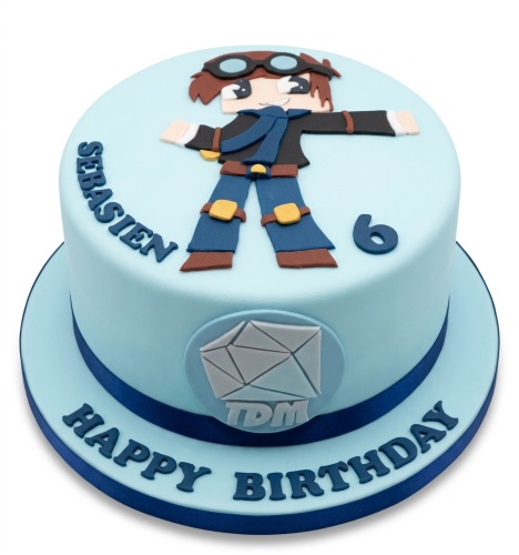 Light blue Minecraft theme birthday cake with block-style character, TDM logo, custom age, and personalised name.