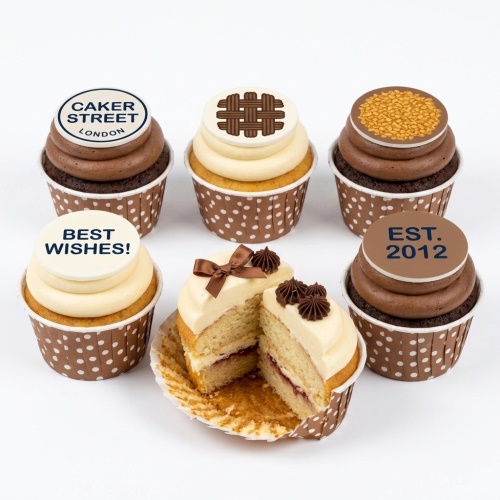 Assortment of chocolate and vanilla cupcakes with custom edible message toppers and chocolate decorations.