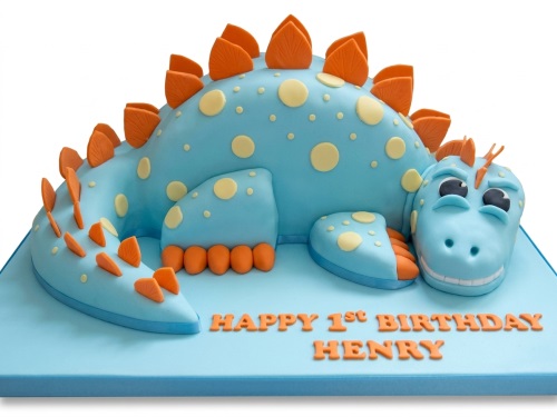 Blue 3D dinosaur birthday cake with orange spikes and yellow dots, personalised with custom age and name.