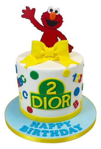 Round white Elmo birthday cake with a red Elmo topper, yellow bow, custom age number, and colourful ABC and 123 decorations.