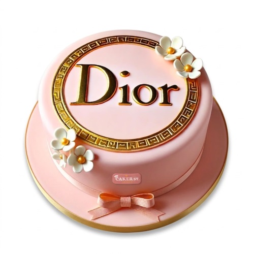 Pink round cake with gold Dior logo, gold trim, white flowers, and pink ribbon.
