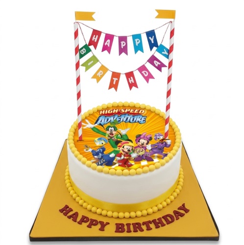Round white birthday cake with Mickey Mouse High-Speed Adventure edible image and "Happy Birthday" banner.