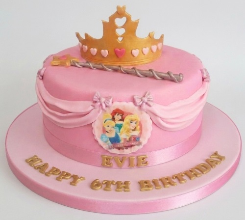 Pink princess birthday cake with gold tiara, magic wand, and edible princess characters. Personalised custom age birthday cake for girls.
