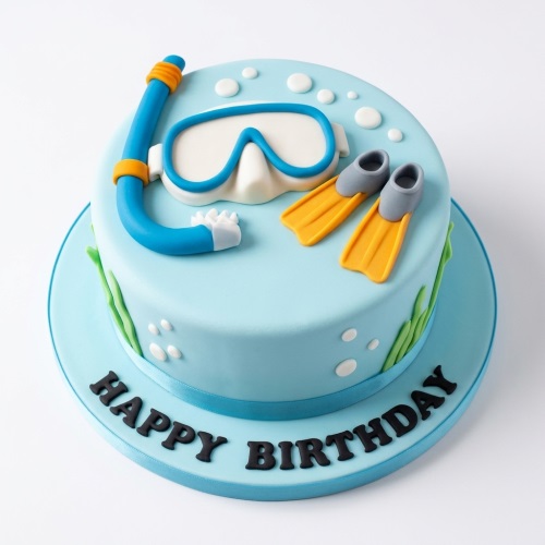 Round blue diving adventure birthday cake with edible snorkel, mask, flippers, and bubbles.