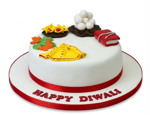 White round cake with Happy Diwali message and traditional Indian festival decorations.