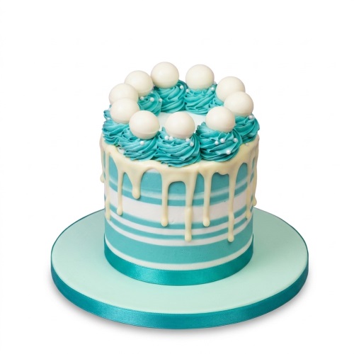 Teal and white striped birthday cake with white drip and chocolate spheres