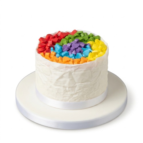 Round white birthday cake topped with colourful rainbow heart decorations.