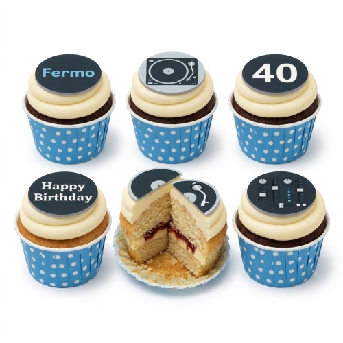 Six cupcakes with cream frosting and blue polka dot wrappers. Toppers show a record player, mixing deck, custom name, custom age, and 'Happy Birthday'. One cupcake is cut open showing jam filling.