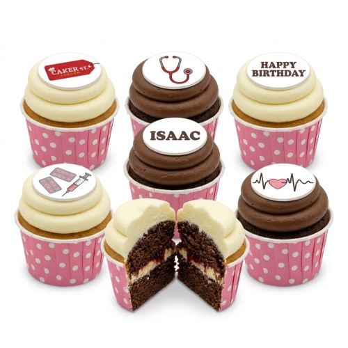Selection of medical theme cupcakes with stethoscope, pills, heartbeat, and 'Happy Birthday' toppers in pink polka dot cases.