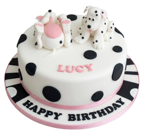 White round birthday cake with black polka dots and two fondant Dalmatian puppies, personalised name and Happy Birthday message.