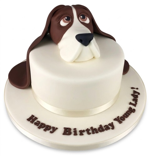 White round birthday cake with a brown and white 3D dog head topper and custom message.