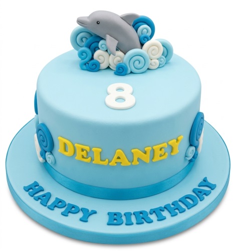 Round blue dolphin theme birthday cake with custom age topper and wave decorations.