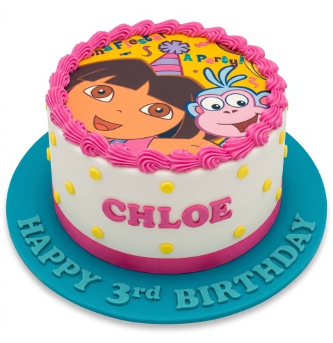 Round white Dora the Explorer birthday cake with pink piping, yellow polka dots, and custom name.